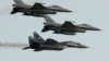 POLAND - Two Polish Air Force Russian made Mig 29's fly above and below two Polish Air Force U.S. made F-16's fighter jets during the Air Show in Radom, Poland, on Aug. 27, 2011